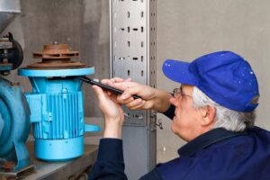 تعمیر کار مشغول روغن کاری پمپ آب